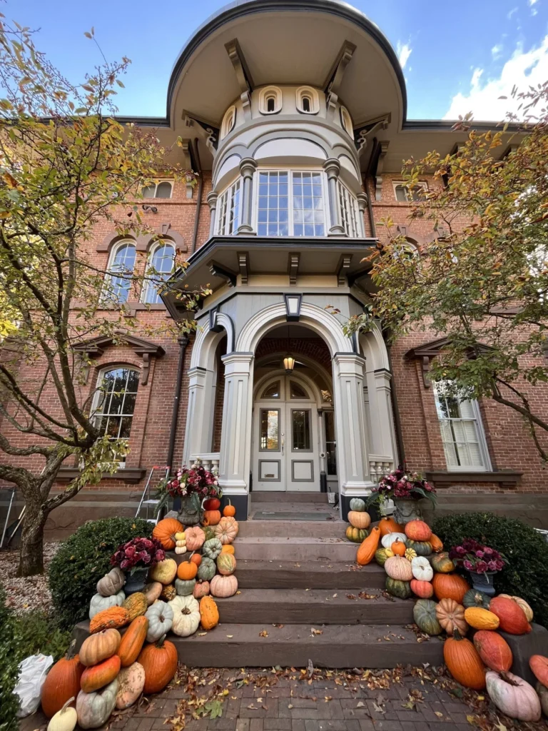 Historic home porch with detailed trim and autumn pumpkins